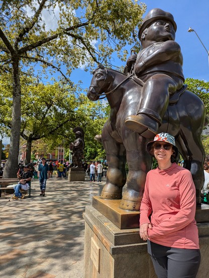 Sally in front of a sculpture of a horse and rider with disproportionate heads.