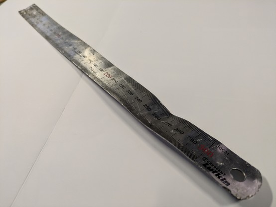 A buckled and bent steel rule