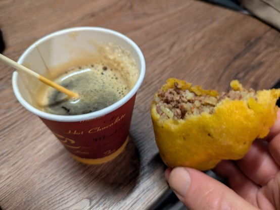 Half-consumed coffee and empanada