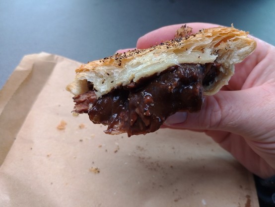An almost-eaten pepper steak pie.