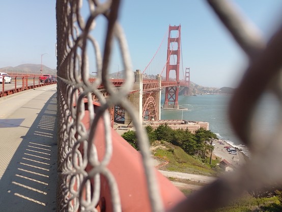 A view of the Golden Gate Bridge through the chain link fence on the approach. No fence once you're over the water, just nets below to stop jumpers (and hats that blow off heads).