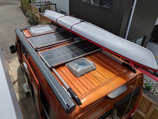 The van with the kayak mounted on the roof. The kayak shades the ends of the solar panels which effectively makes them useless.