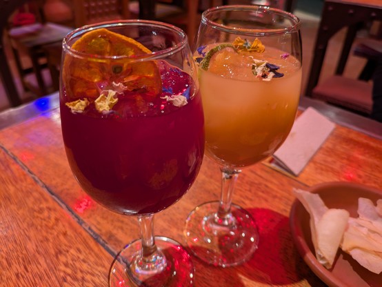 Two wine glasses of chicha. The red one was made with purple corn.