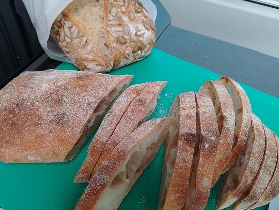 Sliced ciabatta with a still-wraped hot sead loaf behind.
