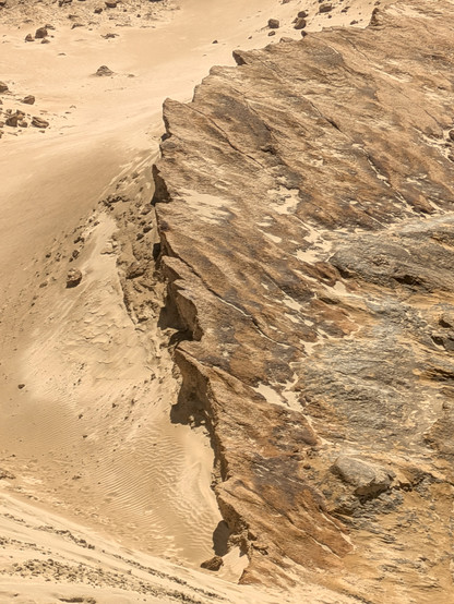 Where the sand has blown away there are exposed cracked craters